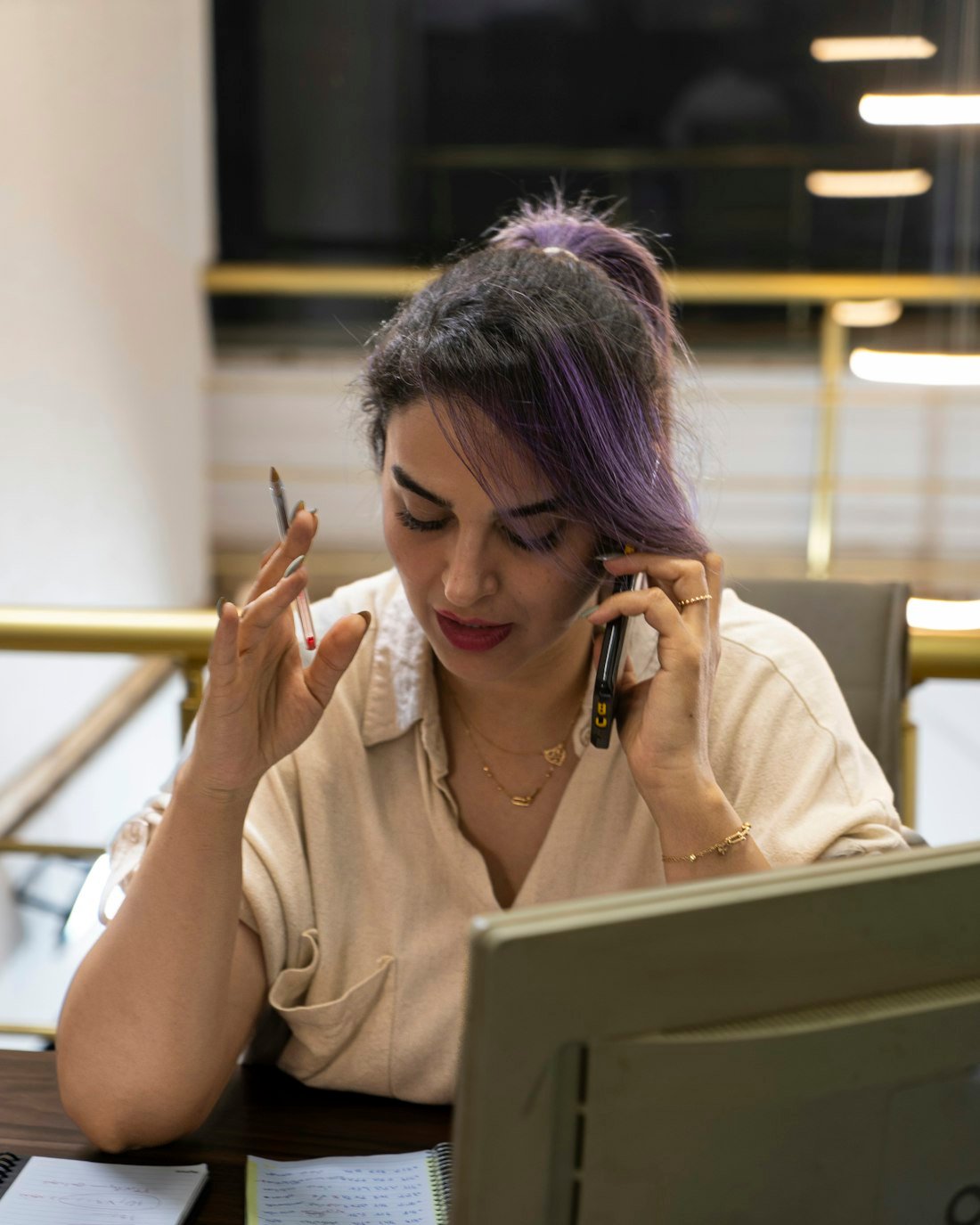 Jonge professional appt op de telefoon aan een bureau